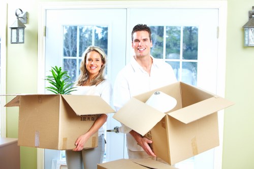 Professional movers carrying items through an Ealing property